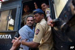 One of the men accused in the 2006 Mumbai train bombings is escorted by policemen from a prison to a court in Mumbai, India, Wednesday, Sept. 30, 2015.