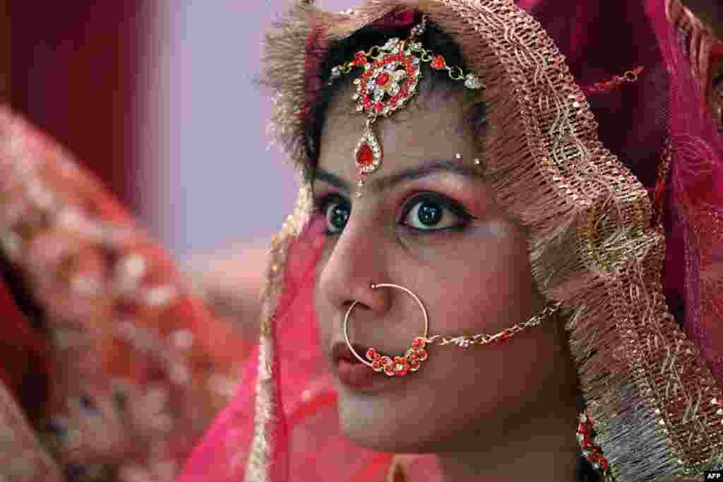 인도 뉴델리의 한 사원에서 열린 합동 결혼식에서 한 신부가 화려한 화장을 하고 있다.