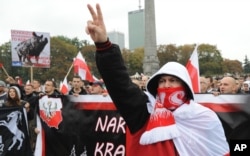 Protesters shout anti-migrant slogans as several thousand right-wing nationalists march through downtown Warsaw, demonstrating against EU-proposed quotas for Poland to spread the human tide of refugees around Europe, Sept. 12, 2015.
