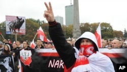 Protesters shout anti-migrant slogans as several thousand right-wing nationalists march through downtown Warsaw, demonstrating against EU-proposed quotas for Poland to spread the human tide of refugees around Europe, Sept. 12, 2015.