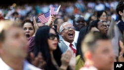 Alfonso Perez, of the Dominican Republic, cheers at the start of a naturalization ceremony for 755 new United States citizens at Turner Field, home of the Atlanta Braves baseball team in Atlanta, Sept. 16, 2016. 