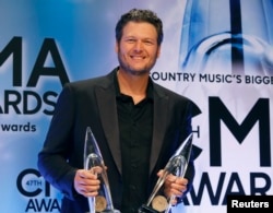 Blake Shelton poses backstage with his Male Vocalist of the Year and Album of the Year awards for "Based on a True Story" at the 47th Country Music Association Awards in Nashville, Tennessee, Nov. 6, 2013.