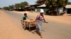 FILE - A woman and her daughter transport a cart of bricks at the Rovieng District in Preah Vihear province on February 10, 2013.