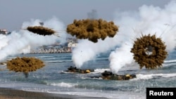 Amphibious assault vehicles of the South Korean Marine Corps throw smoke bombs as they move to land on shore during a U.S.-South Korea joint landing operation drill in Pohang, South Korea, March 31, 2014.