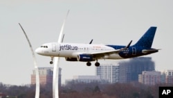 A JetBlue passenger plane passes the Air Force Memorial as it prepares to land at Reagan Washington National Airport in Arlington, Virginia, across the Potomac River from Washington, Jan. 19, 2022. 