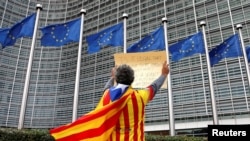 FILE - Catalan Raimon Castellvi wears a flag with an Estelada (Catalan separatist flag) as he protests outside the European Commission in Brussels after an independence referendum in Catalonia, Belgium, Oct. 2, 2017. 