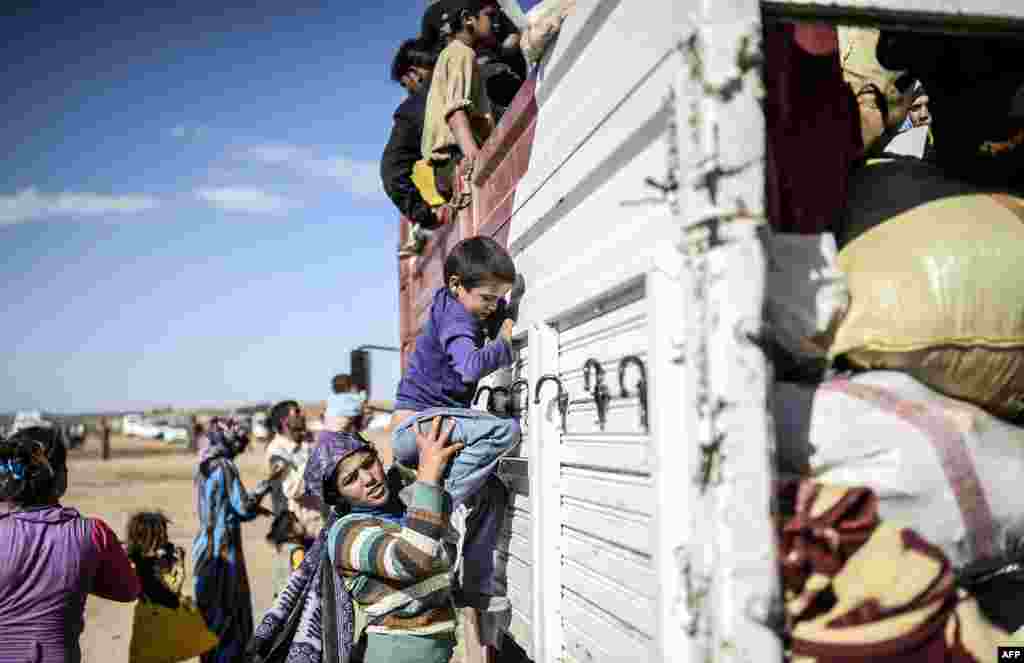 Syrian Kurds get into a bus after crossing the border between Syria and Turkey. Several mortars hit both side in the southeastern town of Suruc, in the Sanliurfa province.