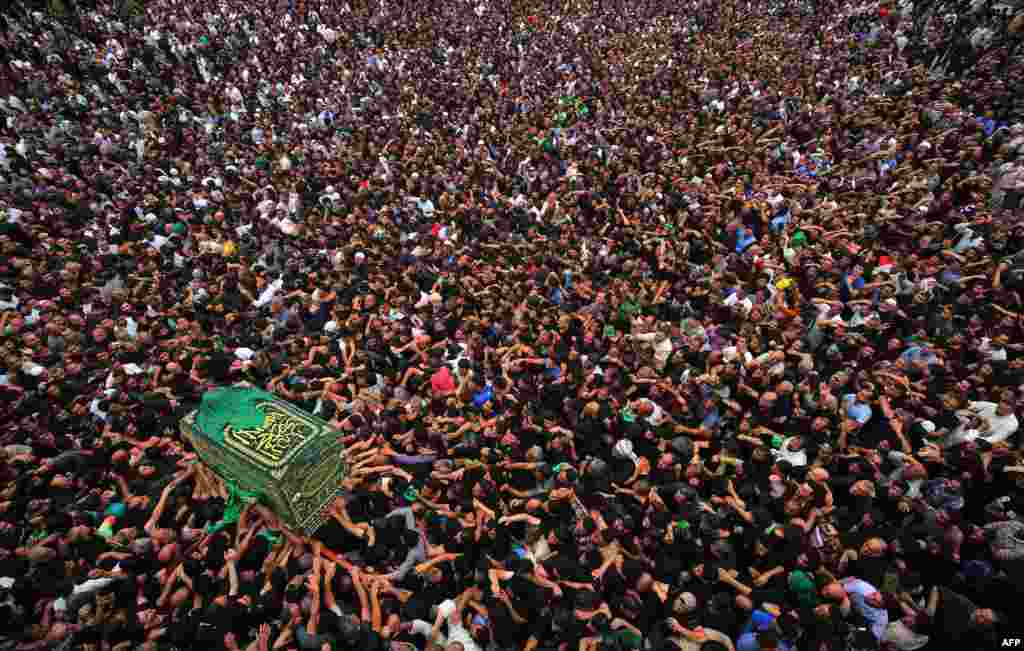 Shiite Muslim worshipers carry a symbolic casket as they gather at the Imam Musa al-Kadhim's mosque in the Iraqi capital’s northern district of Kadhimiya on April 12, 2018 as they mark the anniversary of the Imam's death in the 8th century. 