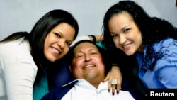 Venezuela's President Hugo Chavez smiles in between his daughters, Rosa Virginia (R) and Maria while recovering from cancer surgery in Havana in this photograph released by the Ministry of Information on February 15, 2013.
