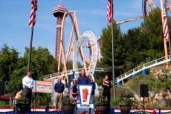 Gubernur California, Gavin Newsom (tengah) menyambut para pengunjung taman hiburan Six Flags Magic Mountain di California, 16 Juni 2021 (dok: David Crane/The Orange County Register via AP)