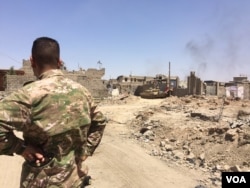 An Iraqi soldier looks at damage done by airstrikes and car bombs in IS's last stronghold, Mosul's Old City, June 18, 2017. (H. Murdock/VOA)