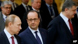 Presiden Rusia Vladimir Putin (kiri), Presiden Perancis Francois Hollande (tengah) dan Presiden Rusia Petro Poroshenko dalam pertemuan di Minsk, Belarus (11/2). (AP/Sergei Grits)