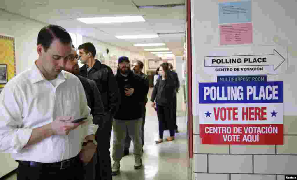 Voters receive their ballot to vote in the Super Tuesday election at Sleepy Hollow Elementary School in Falls Church, Virginia, March 1, 2016.