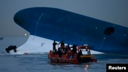 Maritime police search for missing passengers in front of the South Korean ferry that sank near Jindo, South Korea, April 16, 2014. 