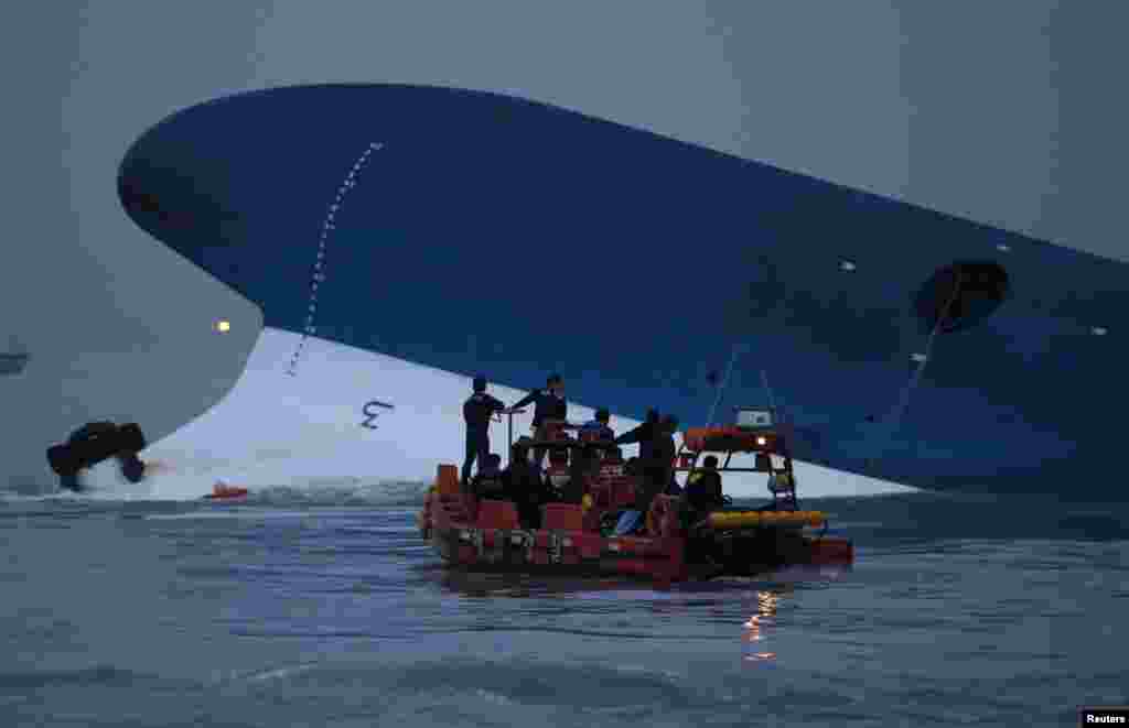 Maritime police search for missing passengers in front of the South Korean ferry that sank near Jindo, South Korea, April 16, 2014. 