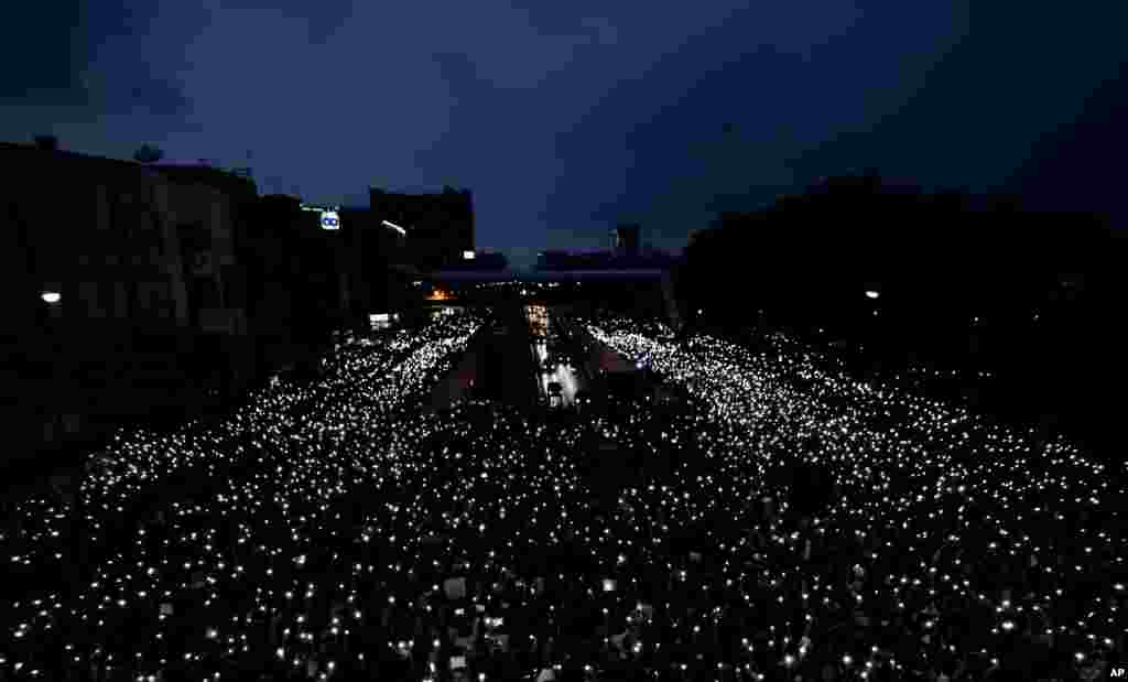 Pro-democracy activists wave mobile phones with lights during a demonstration at Kaset intersection, in Bangkok, Thailand.