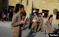 Students of Tevfik Ileri Imam Hatip School walk past a statue of Mustafa Kemal Ataturk, founder of secular Turkey, in Ankara, Nov. 18, 2014.