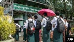 Students wait outside a school entrance in Sittwe, capital of western Rakhine State on June 1, 2021. - Schools in Myanmar opened on June 1 for the first time since the military seized power, but teachers and students are set to defy the junta's calls for 