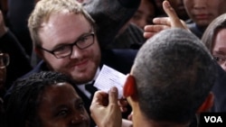 Barack Obama lee una nota de protesta que le entregó un manifestante.