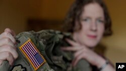 Transgender U.S. army captain Jennifer Sims lifts her uniform during an interview with The Associated Press in Beratzhausen near Regensburg, Germany, July 29, 2017.