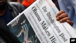 FILE - People line up outside of the Washington Post newspaper to purchase special election editions in Washington, Nov. 5, 2008.