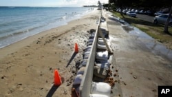 In this June 23, 2017 photo, sand bags line the beach at Ala Moana Beach Park in Honolulu as record high tides hit the islands. Some of Hawaii's most iconic beaches could soon be underwater. (Honolulu Star-Advertiser, Bruce Asato via AP)