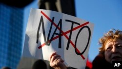 Seorang warga pro-Rusia membawa poster anti-NATO di Ukraina