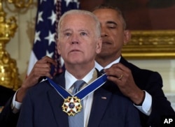 FILE - In this Jan. 12, 2017, file photo President Barack Obama presents Vice President Joe Biden with the Presidential Medal of Freedom during a ceremony in the State Dining Room of the White House in Washington. (AP Photo/Susan Walsh, File)