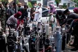 Warga berkumpul untuk mengisi tangki oksigen di sebuah stasiun di Yogyakarta pada 14 Juli 2021. (Foto: AFP/Agung Supriyanto)