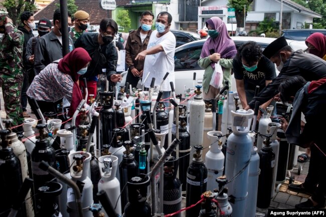 Warga berkumpul untuk mengisi tangki oksigen di sebuah stasiun di Yogyakarta pada 14 Juli 2021. (Foto: AFP/Agung Supriyanto)