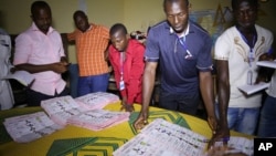 Electoral officials sort out ballot papers at the end of presidential elections in Conakry, Guinea, Oct. 11, 2015. 
