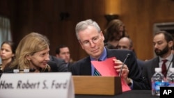 FILE - Robert Ford, U.S. ambassador to Syria, arrives to testify to the Senate Foreign Relations Committee about the conflict in Syria, on Capitol Hill in Washington, Thursday, Oct. 31, 2013. At left is Nancy Lindborg, an official with the U.S. Agency for International Development. (AP Photo/J. Scott Applewhite)