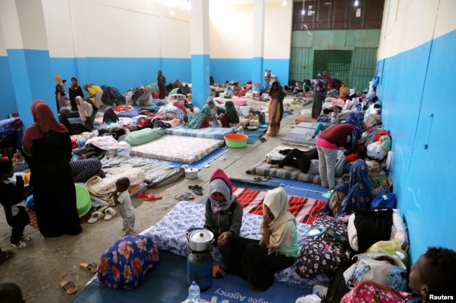 FILE - Migrants are seen at a detention center in Zawiya, west of Tripoli, Libya, April 26, 2019.