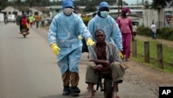 Residents of the St. Paul Bridge neighborhood wearing personal protective equipment take a man suspected of having Ebola to the Island Clinic in Monrovia, Liberia, Sept. 28, 2014. 