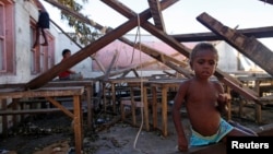 FILE - Children play in a destroyed school classroom in Tanna, March 18, 2015, after a powerful storm wiped out crops and destroyed fishing fleets, raising the risk of hunger and disease.