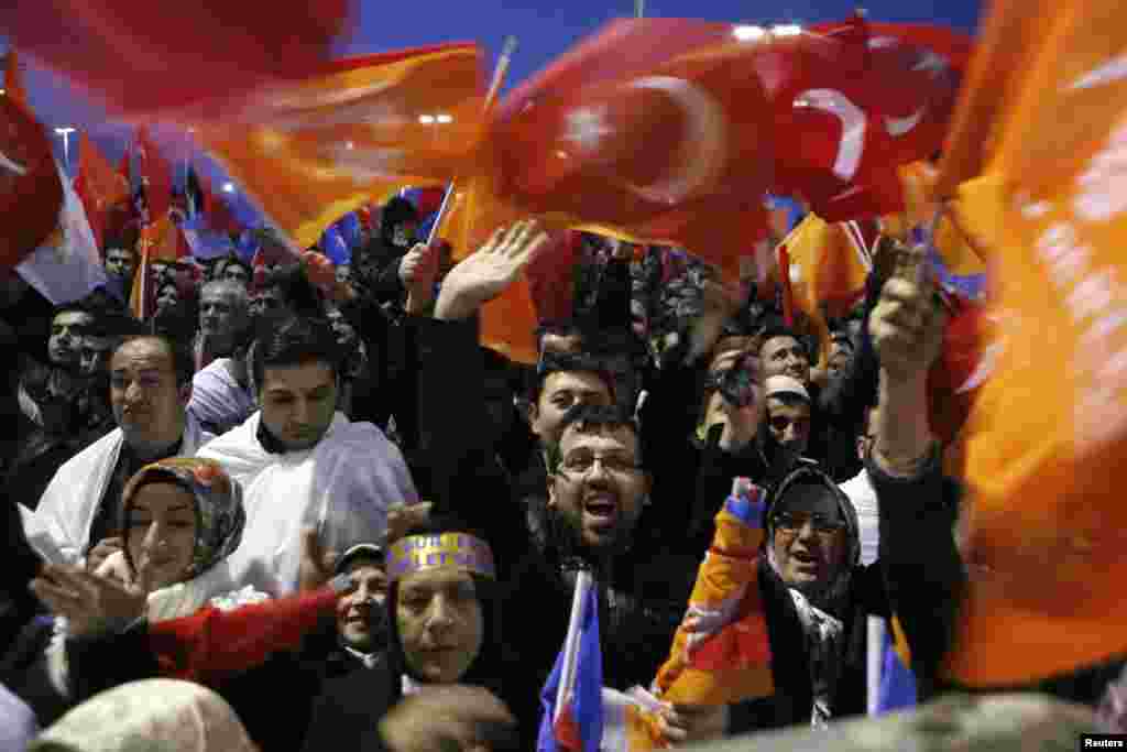 Supporters of Turkey&#39;s PM Tayyip Erdogan shout slogans as they gather to welcome his arrival at Ataturk Airport in Istanbul. A Turkish court blocked a government attempt to force police to disclose investigations to their superiors in a setback for Erdogan&#39;s attempts to manage fallout from a high-level corruption scandal.