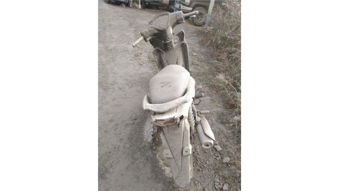 Sebuah sepeda motor di Desa Gung Pinto, Kecamatan Naman Teran, Kabupaten Karo, Sumut yang diselimuti abu vulkanik dari Gunung Sinabung, Sabtu 8 Agustus 2020. (Courtesy: BPBD Karo)