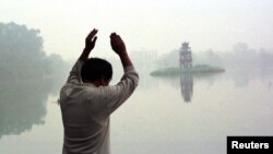 Hình ảnh Hồ Hoàn Kiếm mờ ảo trong một sáng Chủ Nhật khi người dân đi tập thể dục