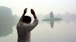Hình ảnh Hồ Hoàn Kiếm mờ ảo trong một sáng Chủ Nhật khi người dân đi tập thể dục