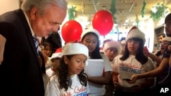 niños vestidos con gorros rojos de Navidad le entregaron al alcalde un centenar de cartas en las que expresan que su deseo para esta Navidad es que sus padres no sean deportados.