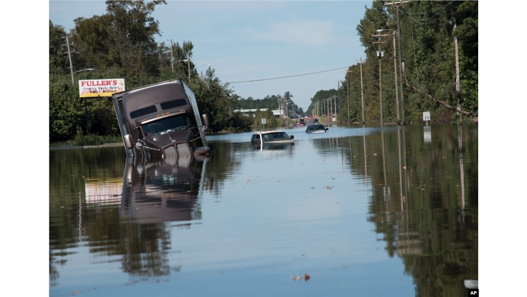 A tractor trailer truck is submerged in floodwaters caused by rain from Hurricane Matthew on Highway NC 211 near the Mayfair neighborhood in Lumberton, North Carolina, Oct. 11, 2016.