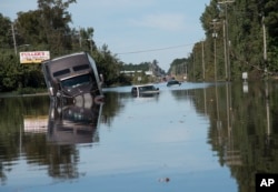 A tractor trailer truck is submerged in floodwaters caused by rain from Hurricane Matthew on Highway NC 211 near the Mayfair neighborhood in Lumberton, North Carolina, Oct. 11, 2016.