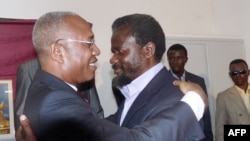 L'ancien dirigeant rebelle Frédéric Bintsamou, alias "Pasteur Ntumi", à droite, embrasse Firmin Ayessa, Directeur du cabinet du président de la République du Congo, à gauche, lors d'une cérémonie à Brazzaville, le 28 décembre 2009. 