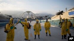 Health workers get ready to spray insecticide to combat mosquitoes in Rio de Janeiro at the 2016 summer games. The insects transmit the Zika virus. (AP File Photo/Leo Correa)