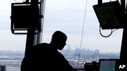 FILE - An air traffic controller works in the tower at Newark Liberty International Airport, May 21, 2015, in Newark, N.J. The Federal Aviation Administration demonstrated to media a system, called Data Comm, that will allow for electronic communication between air traffic controllers and pilots aimed to cut delays.