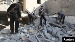 Free Syrian Army fighters and civilians search for bodies under rubble after an air strike by a fighter jet loyal to Syrian President Bashar al-Assad in Aleppo's al-Marja district December 31, 2012.