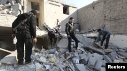 31일 정부군의 공격으로 무너진 건물 더미에서 동료의 사체를 찾는 반군 병사들. (자료사진)