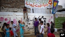 Pakistani Christian children play under a banner condemning the arrest of a Christian girl in Islamabad, Pakistan, Aug. 21, 2012.