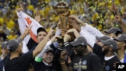 金州勇士队6月12日击败克里夫兰骑士队,赢得NBA冠军,球员、教练和球队老板高举奖杯