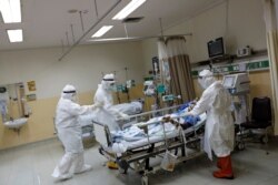 Para petugas medis mengenakan baju pelindung bersiap memindahkan pasien ke ruang bedah, dari Unit Perawatan Intensif untuk pasien Covid-19, di Rumah Sakit Persahabatan di Jakarta, 13 Mei 2020.(Foto: Reuters)